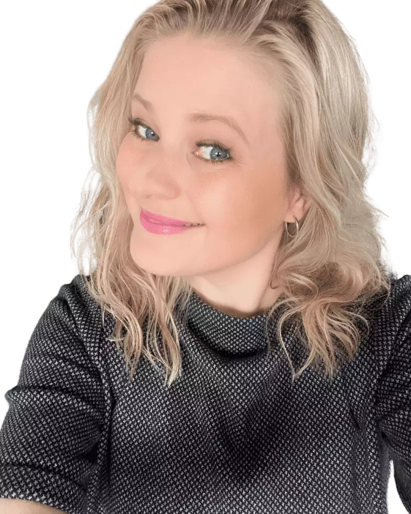 A woman (Gyde Balzer Carstensen) with blonde hair smiles at the camera, showcasing her short-sleeved, dark grey top from the STOP-TYVEN-PAKKEN collection.